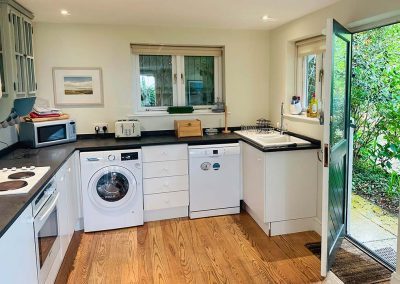 The front door leading into the kitchen, dishwasher